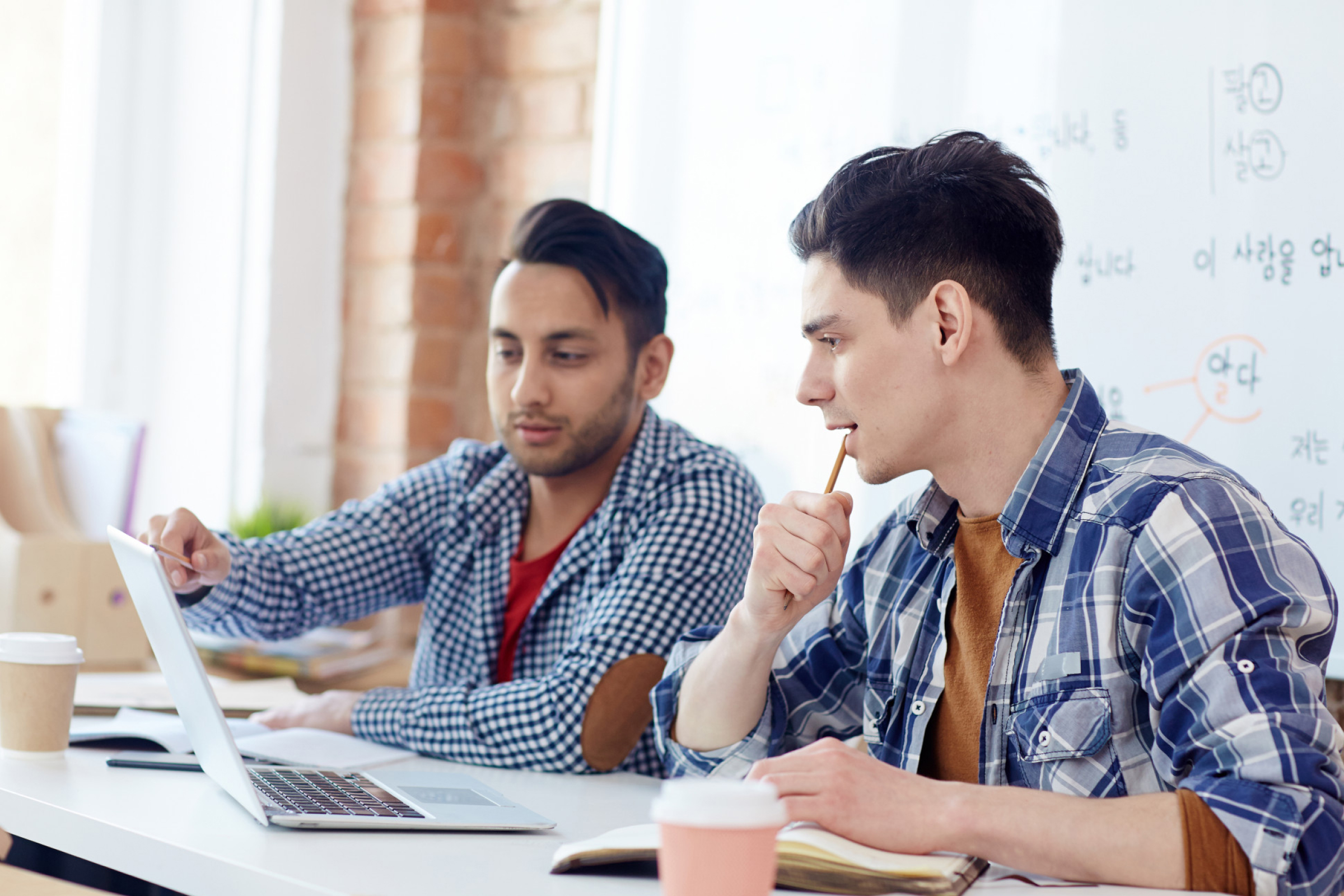 Two students working together on a laptop